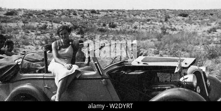 Eva Braun Collection (album 4) - femme assise sur une voiture bloqué dans le sable d'une plage près de Viareggio, Italie Banque D'Images