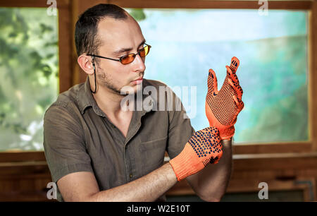 Jeune homme dans les verres en portant des gants protecteurs Banque D'Images