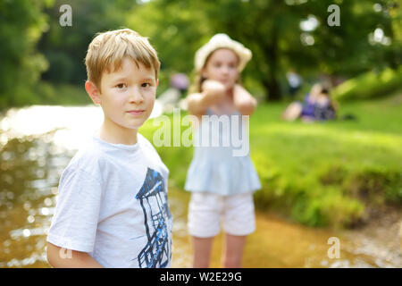 Frère et sœur s'amuser ensemble sur la journée d'été chaude et ensoleillée dans city park. Frères et sœurs mignon d'avoir un bon temps à explorer la nature. Loisirs famille fo Banque D'Images