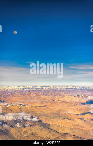 Pleine lune sur les montagnes arides de l'intérieur de la gamme du Zanskar Himalaya, l'Inde. Prises d'un avion sur un début de juillet matin. Orientation Portrait. Banque D'Images