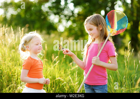 Deux petites soeurs attraper les papillons et d'insectes avec leur scoop-nets. Enfants découverte de la nature aux beaux jours d'été. Loisirs en famille avec des enfants de somme Banque D'Images