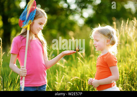 Deux petites soeurs attraper les papillons et d'insectes avec leur scoop-nets. Enfants découverte de la nature aux beaux jours d'été. Loisirs en famille avec des enfants de somme Banque D'Images