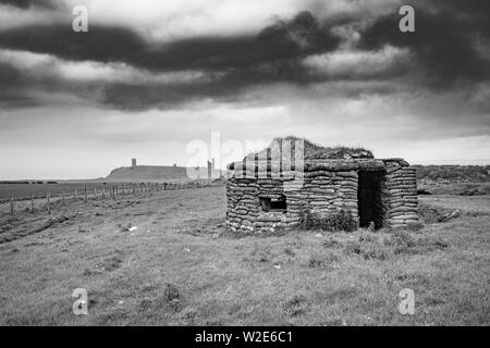 Guerre Mondiale deux Pilllbox avec Château de Dunstanburgh dans la distance, Northumberland, Angleterre Banque D'Images