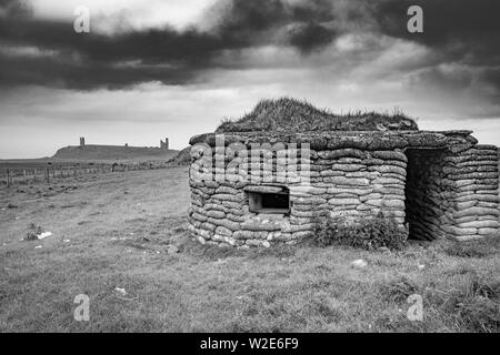 Guerre Mondiale deux Pilllbox avec Château de Dunstanburgh dans la distance, Northumberland, Angleterre Banque D'Images