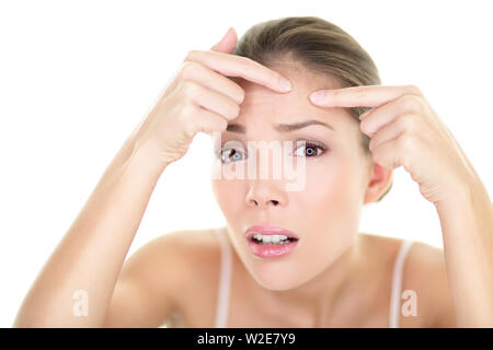 Spot spot de bouton d'acné de la peau soins de beauté fille agissant sur problème de peau visage. Femme avec la peau à imperfections isolées miroir au fond blanc. Beautiful Young Asian Woman modèle féminin. Banque D'Images