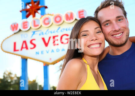 Couple de touristes de Las Vegas à Las Vegas sign. Happy tourist couple taking self-portrait en face de panneau Welcome to Fabulous Las Vegas. Beaux jeunes gens multi-ethnique Asian Woman man. Banque D'Images