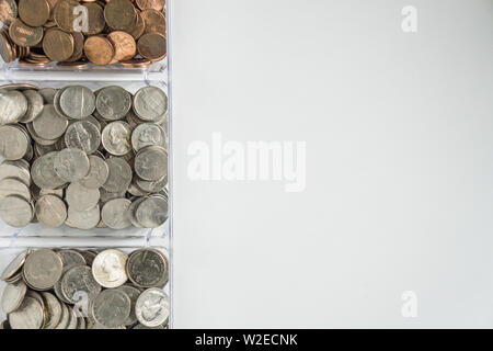 Changement de monnaie en vrac organisé isolé sur le côté gauche, fond blanc, vierge salle vide de l'espace pour copier ou de texte sur la droite. Organisation financière argent co Banque D'Images