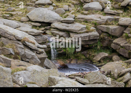 Un ruisseau coule sur le plateau de Kinder Scout, parc national de Peak District, Derbyshire, Angleterre, RU Banque D'Images