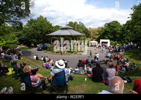 Les résidents de Huddersfield, Yorkshire de l'UK se rassemblent dans le parc de Beaumont sur un week-end d'été ensoleillé pour pique-niquer et profiter des animations proposées au kiosque Banque D'Images