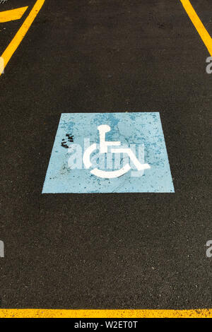 Symbole du fauteuil roulant peint sur la surface d'un parking pour désigner une voiture de stationnement pour personnes à mobilité réduite, Banque D'Images