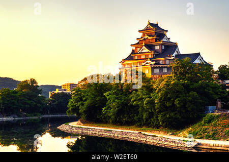 Okayama, Japon. Château à Okayama, Japon le matin avec river et coloré ciel jaune au lever du soleil. Reflet dans l'eau Banque D'Images