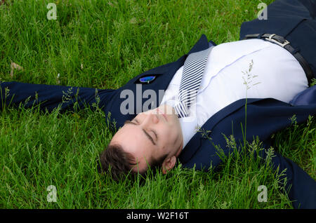 Portrait of handsome businessman relaxing outdoor dans l'herbe verte au travail, porter une cravate, tailleur, chemise blanche, blanc, de repos d'Europe Banque D'Images