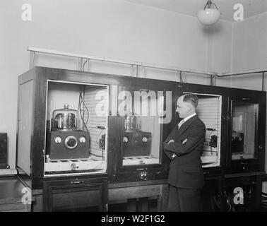 Homme avec un groupe de 100 kHz oscillateurs à cristal de quartz qui a servi comme le U.S. National fréquence primaire standard en 1929 ca. 1930 Banque D'Images