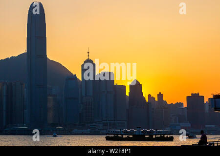 Coucher du soleil skyline et ferry, le port de Victoria, Hong Kong, SAR, Chine Banque D'Images