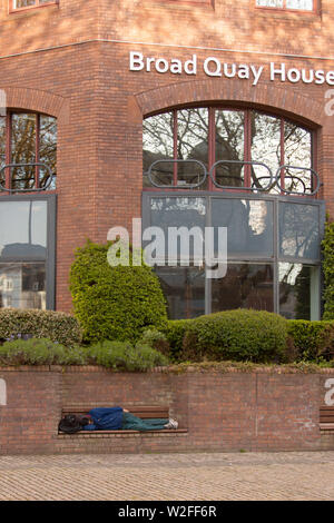 Personne sans-abri dormant sur un banc, Large Quay House Banque D'Images