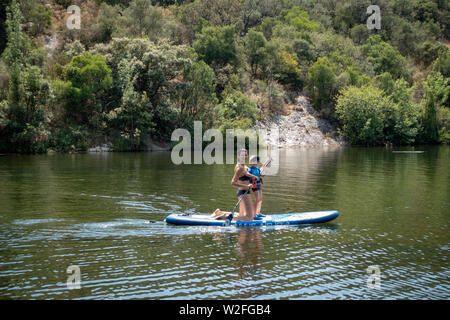 Jeune mère de l'enseignement d'un petit garçon comment utiliser un Paddle Board sur un lac Banque D'Images