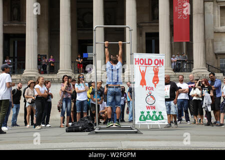 Spectacle sur Trafalgar Square difficile les touristes et les Londoniens de tenir pendant deux minutes (hommes) ou d'une minute et demie (femmes) de gagner €100. Banque D'Images