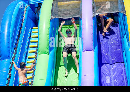 Prescott, Arizona, USA-Juillet 6, 2019 : en glissant sur un toboggan gonflable à la guerre de l'eau, sur le Mile de haut en bas sur le terrain de l'école intermédiaire Banque D'Images