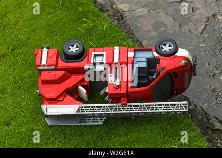 Fire Engine Toy abandonnés sur l'herbe lone sous la pluie. Banque D'Images