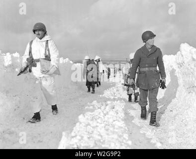 Légende originale : fantassins américains d'une division blindée de mars une route au sud-est de naissance, Belgique. Remarque La hauteur de l'amoncellement de neige de chaque côté de la route. 1/22/45. Co. C, 23e Armd. Inf, bn., 7e Armd. Banque D'Images