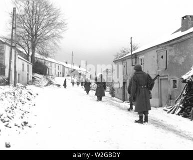 À la recherche de tireurs d'allemand, une escouade de fantassins Troisième armée avancer avec prudence dans les rues de Moircy, Belgique. 31/12/44 Banque D'Images