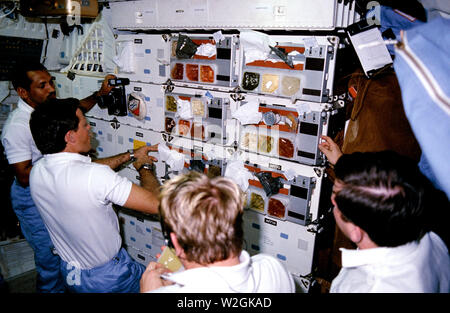 (12-18 janv. 1986) --- Les astronautes Charles F. Bolden, STS-61C pilote ; Robert Gibson, commandant ; George D. Nelson, spécialiste de mission, spécialiste de charge utile et Robert J. Cenker (RCA) queue à 'chow line' sur le compartiment intermédiaire de la navette spatiale Columbia. Banque D'Images
