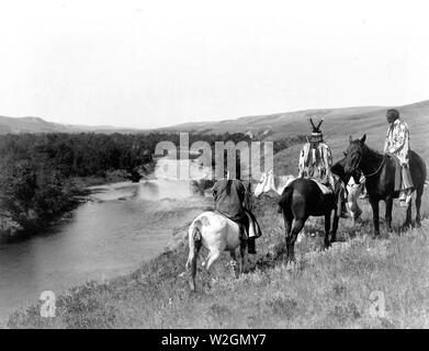 Edward S. Curits indiens des États-Unis - trois Indiens Piegan et quatre chevaux sur la colline au-dessus de river ca. 1910 Banque D'Images