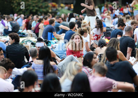 New York, USA. 8 juillet, 2019. Les gens attendent pour le début d'un film en plein air show à Bryant Park à New York, États-Unis, 8 juillet 2019. Comme l'été arrive, piscine extérieure et intérieure film les épisodes de dépistage sont très populaires dans toute la ville, attirant des milliers de personnes à profiter de leurs nuits d'été. Credit : Wang Ying/Xinhua/Alamy Live News Banque D'Images