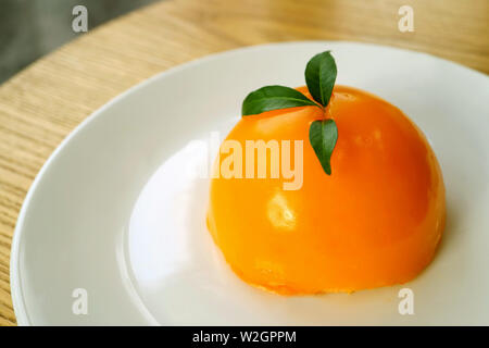 Mandarin appétissants gâteaux Orange Dome sur une plaque blanche Banque D'Images