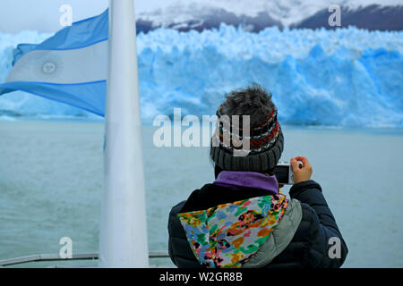 Woman prendre des photos de l'impressionnant mur de Glacier Perito Moreno Glacier du bateau de croisière sur le lac Argentino, Patagonie, Argentine Banque D'Images