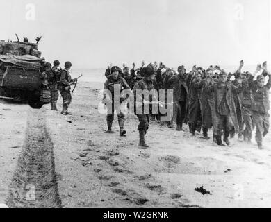 [Légende ORIGINALE] soldats américains mars un groupe de prisonniers allemands le long d'un pont dans le Nord de la France, après quoi ils seront envoyés à l'Angleterre. Banque D'Images