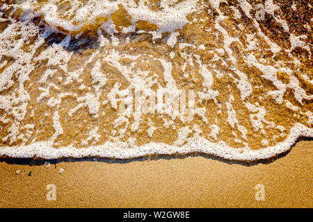 Low angle view sur une petites vagues sur le littoral, la mer avec des vagues écumeuses. Banque D'Images