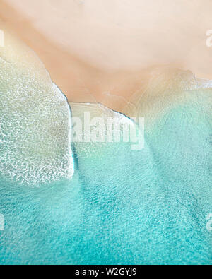 Vue aérienne de la plage avec de belles vagues, le sable blanc et les textures de l'océan au lever du soleil dans une ville au bord de l'Australie Banque D'Images