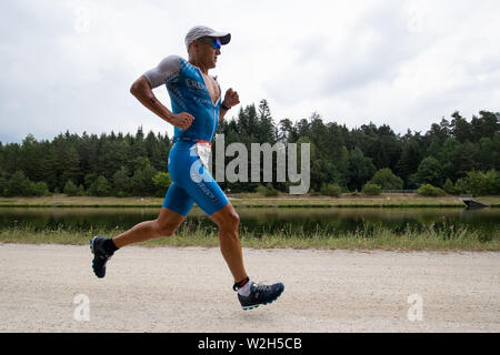 Roth, en Allemagne. 07Th Juillet, 2019. Andreas Dreitz, triathlète de l'Allemagne, s'étend le long du canal à la Datev Challenge Roth. Dans la 18e édition du triathlon, les participants ont dû nager 3,8 km, vélo 180 km et courir 42 kilomètres. crédit : Daniel Karmann/dpa/Alamy Live News Banque D'Images