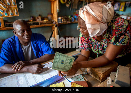 Client de la microfinance dans son atelier avec un employé d'une institution de microfinance au Togo. Banque D'Images