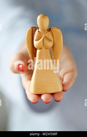 Main d'une femme tenant un ange. Close-up. Banque D'Images