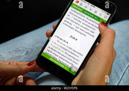 La lecture d'une femme chrétienne bible numérique sur un smartphone. Banque D'Images
