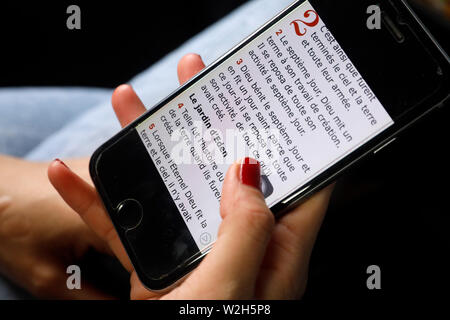 La lecture d'une femme chrétienne bible numérique sur un smartphone. Banque D'Images