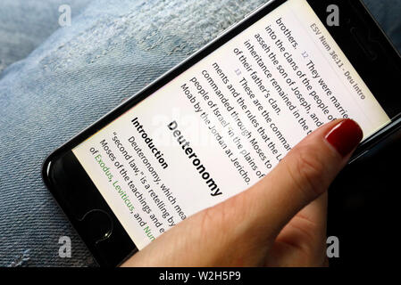 La lecture d'une femme chrétienne bible numérique sur un smartphone. Banque D'Images