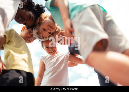 Groupe d'enfants qui se pencher en avant pour l'autre. Banque D'Images