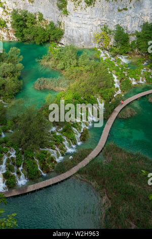 Les randonneurs passant cascades d'eau vers le bas dans le lac Kaluđerovac couleur turquoise au parc national des Lacs de Plitvice en Croatie