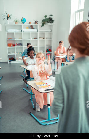 Les enfants de l'école de mains pendant la leçon. Banque D'Images