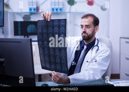 Portrait de jeune médecin regardant un cerveau x ray. Médecin donnant un diagnostic. Tomodensitométrie cérébrale. Banque D'Images