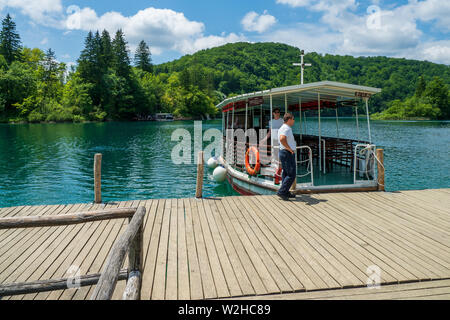 Ferry amarré à l'embarcadère du cristal couleur turquoise clair et pur Lac Kozjak, le parc national des Lacs de Plitvice, Croatie, accueillant les touristes Banque D'Images