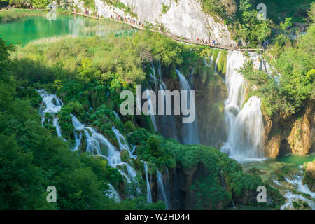 Les touristes à marcher le long de la promenade en bois au-dessus de la grande cascade au parc national des Lacs de Plitvice en Croatie Banque D'Images