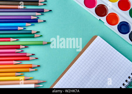 Palette d'aquarelles, carnet d'esquisses et crayons multicolores. Banque D'Images