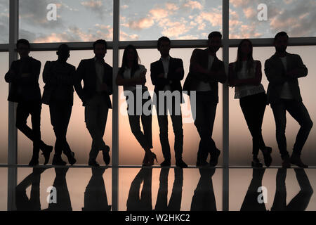Silhouette d'une équipe entreprises debout à côté de la fenêtre du bureau Banque D'Images