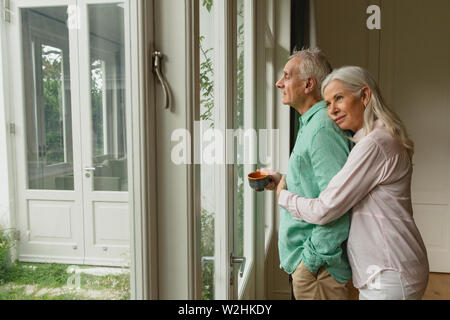 Active senior woman embracing man, située près de la porte Banque D'Images