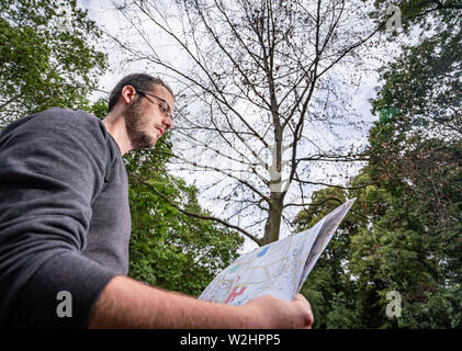 09 juillet 2019, Hessen, Frankfurt/Main : Arboriste Pablo Ellermann se trouve dans l'Günthersburgpark avec une liste des arbres sous un hêtre rouge séché. Lors d'une conférence de presse, le Frankfurter Grünflächenamt informés sur les conséquences de la sécheresse de l'an dernier. Plus de 30 arbres sont morts dans le parc et doivent être abattus pour des raisons de sécurité. Photo : Frank Rumpenhorst/dpa Banque D'Images