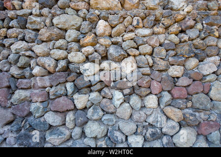 La texture des pierres et pavés avec des arêtes vives. Pierres naturelles fixées dans le mur. Banque D'Images
